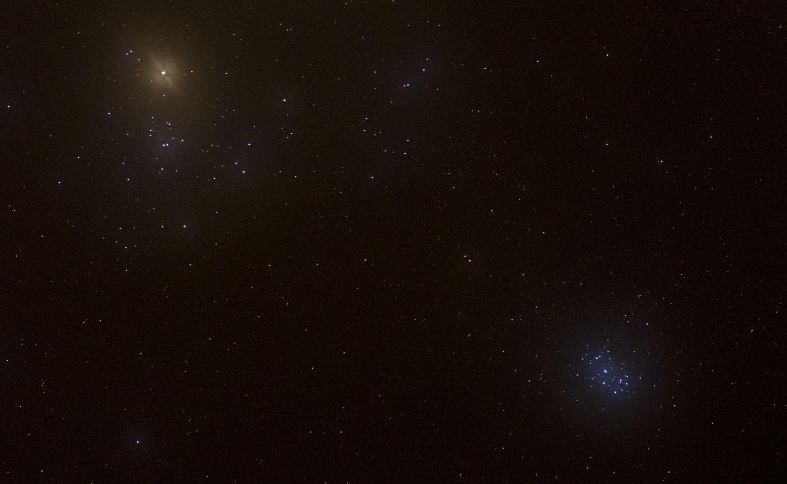 De Hyaden (linksboven, met de heldere oranje ster Aldebaran op de voorgrond) en de heldere blauwe Plejaden (rechtsonder). Foto Philippe Mollet